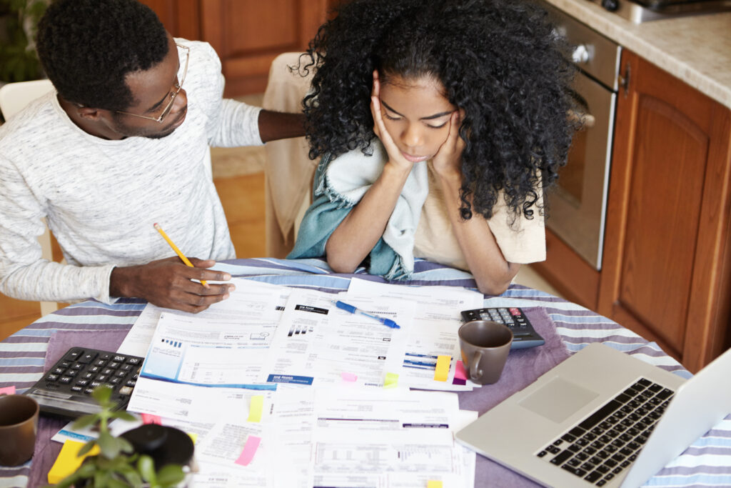 Couple looking over multiple debt documents and bills at home.