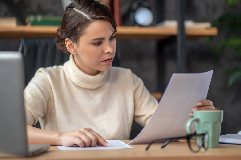 concentrated lady examining documentation desk