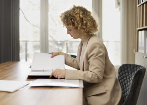 erson reviewing paperwork calmly at a desk with a laptop