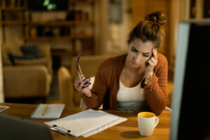 Stressed person looking at credit card statements at a kitchen table