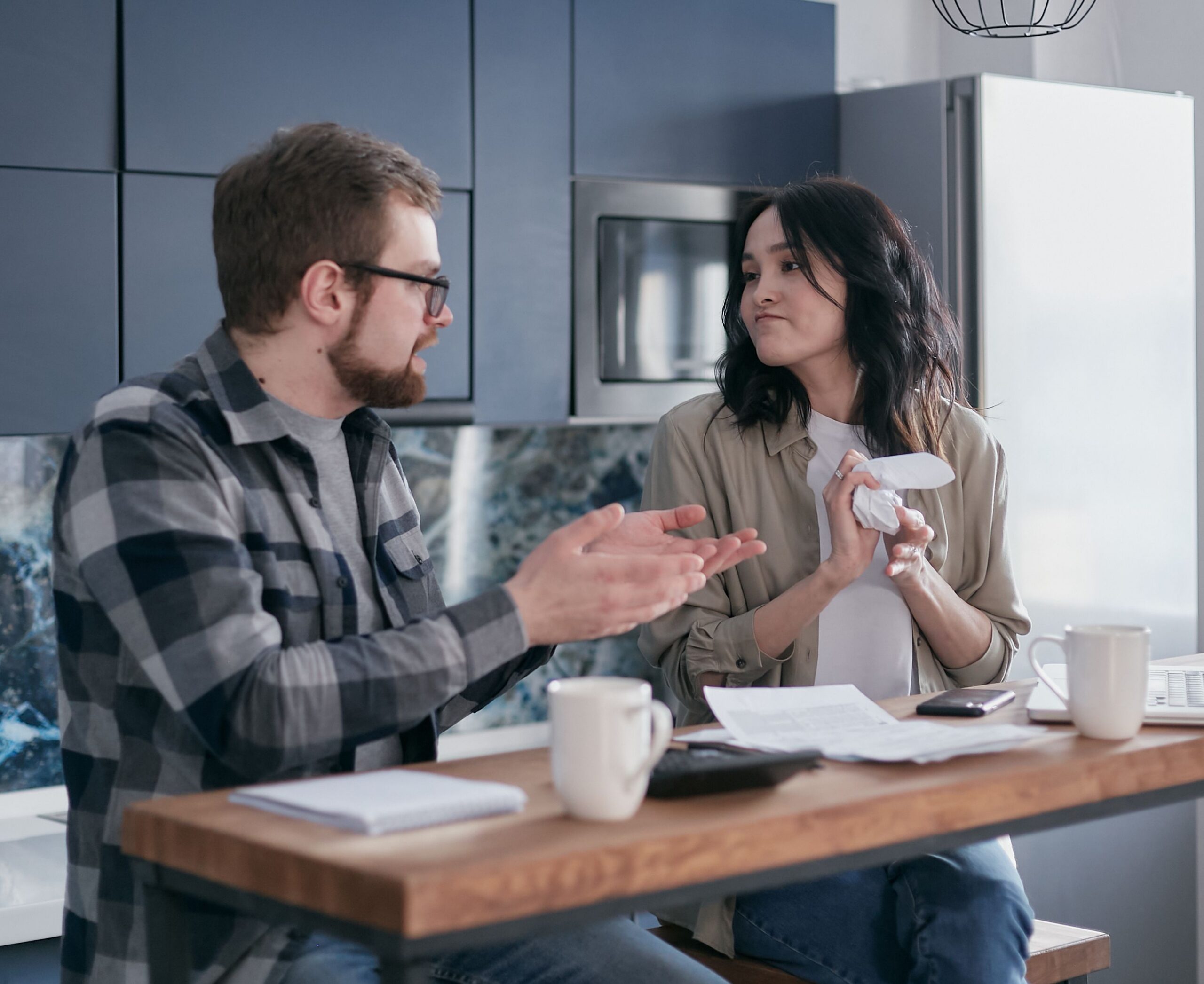 Couple at a kitchen table comparing debt relief and bankruptcy options