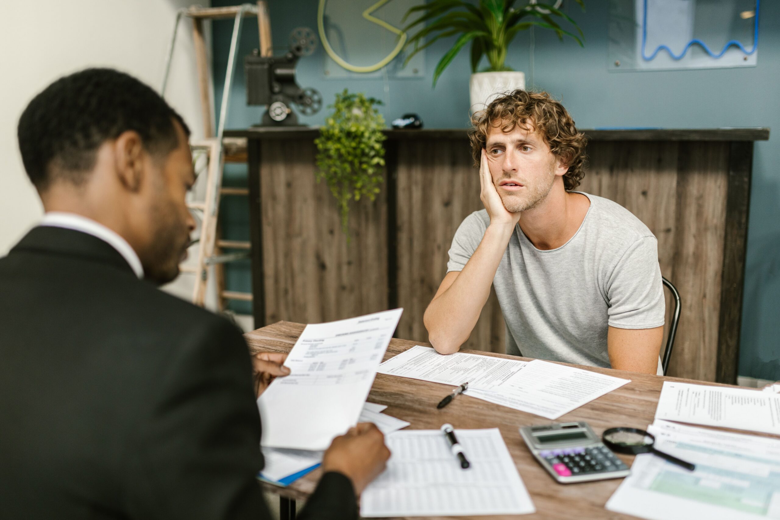 Financial advisor reviewing paperwork with a concerned client during a consultation.